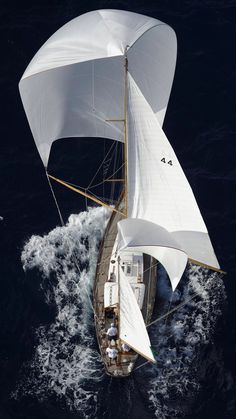 an aerial view of a sailboat sailing in the open ocean, with sails down