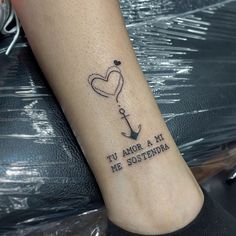 a tattoo on the foot of a person with a heart and an anchor in it