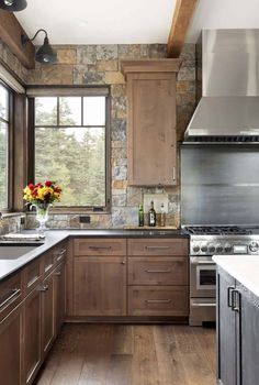 a kitchen with wooden cabinets and stainless steel stove top oven in the center, surrounded by wood flooring