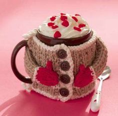 a knitted coffee cup cozying with cream and chocolate in the shape of a sweater