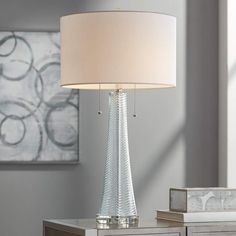 a white lamp sitting on top of a table next to a dresser