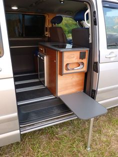 the interior of a van with its door open and an entertainment center in the back