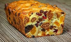 a loaf of fruit bread sitting on top of a wooden table