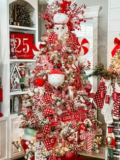 a red and white christmas tree decorated with candy canes, candies, santa claus