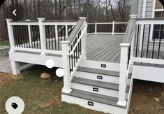 a deck with stairs and railings in front of a house