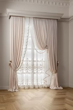 an empty room with wooden floors and curtains