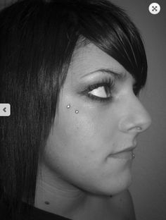 a woman with piercings on her nose looking at the camera