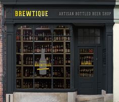 a store front with bottles on display in the window and an open door that says brewtique