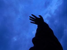 a hand reaching up into the sky