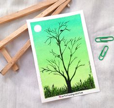 an image of a tree on a card next to crayons and paper clips