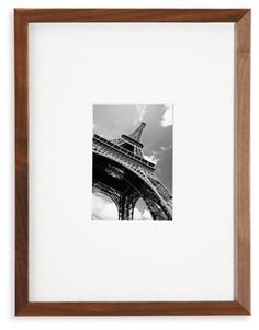 the eiffel tower in black and white is framed by a brown wooden frame