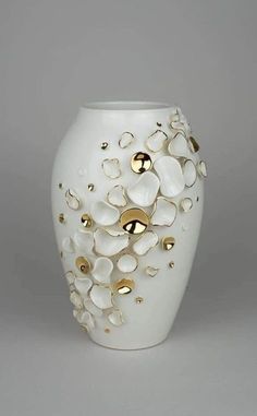 a white vase with gold accents on it