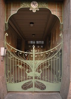 an iron gate is opened to reveal the number twenty on it's front door