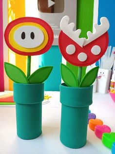 two flower vases with paper flowers in them on a table next to other crafting supplies