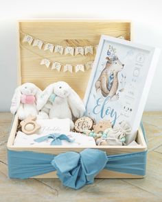 a wooden box filled with stuffed animals next to a baby's first year sign