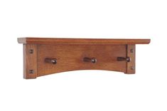 a wooden shelf with three knobs and two holes on the top, against a white background