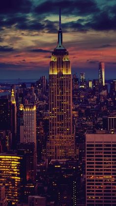 the empire building is lit up at night in new york city, ny with its lights on