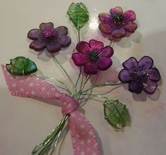 purple flowers with green leaves and pink ribbon