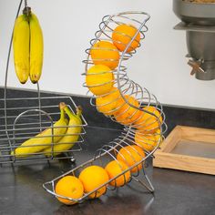 oranges and bananas in a metal spiral basket