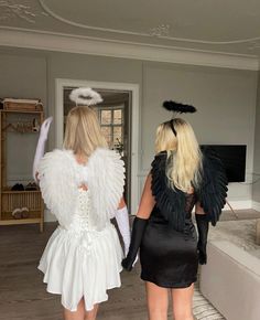 two women dressed in costumes walking towards a living room