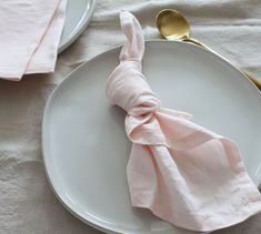 a white plate topped with a pink napkin