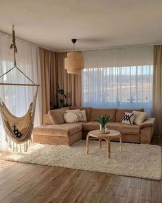 a living room with a hammock hanging from the ceiling next to a couch