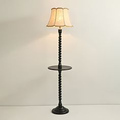 a lamp that is sitting on top of a table next to a white wall and floor