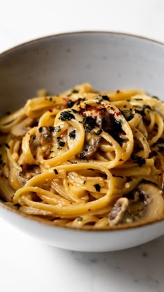 a white bowl filled with pasta and mushrooms