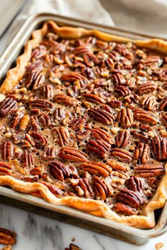 a pie with pecans on top in a pan