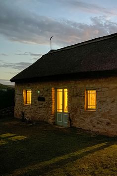 a stone building with two windows lit up at night