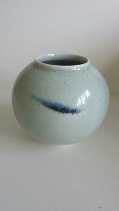 a white and blue vase sitting on top of a table