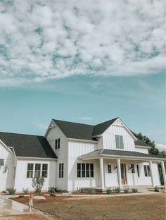 a large white house sitting on top of a lush green field