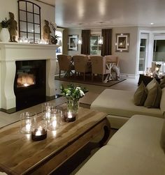 a living room filled with furniture and a fire place in the middle of a room