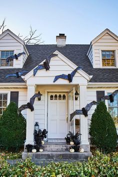 a white house decorated for halloween with bats and pumpkins