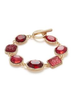 This exquisite gold-tone bracelet exudes elegance and sophistication. Crafted with meticulous attention to detail, it features a unique toggle closure, ensuring a secure and comfortable fit. The bracelet's sleek design is adorned with a captivating red stone, adding a touch of vibrant color and making it a perfect accessory for any occasion. Whether you're dressing up for a special event or adding a touch of glamour to your everyday look, this bracelet is sure to turn heads and make a lasting impression. | evie & emma Gold Tone Red Stone Toggle Bracelet, 7 in Toggle Bracelet, Red Stone, Gold Tone Metal, Special Event, Everyday Look, Sleek Design, Special Events, Jewelry Bracelets, Gold Tones