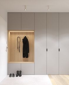 a coat and shoes are hanging on the wall in front of some closets with doors