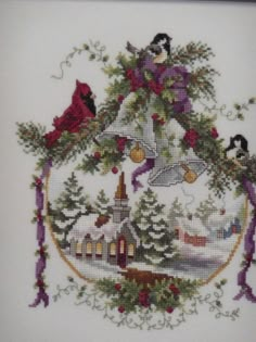 a cross stitch christmas tree with birds on it