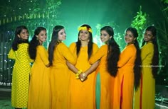 the girls are all dressed in bright yellow dresses