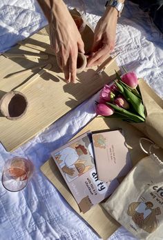 a person cutting up some flowers on top of a wooden board with paper and scissors