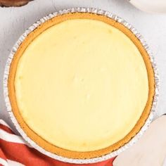 a pie sitting on top of a white table next to a red and white striped towel