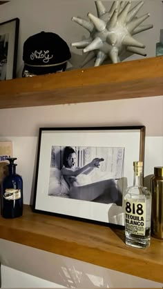 a shelf with bottles and pictures on it