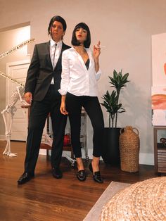 a man and woman dressed in business attire standing next to each other on a wooden floor