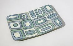 a close up of a cell phone case on a white surface with blue and green designs