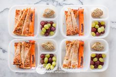 several trays filled with different types of food on top of a marble countertop