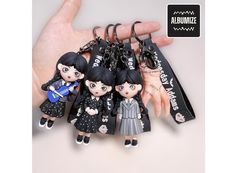 a bunch of little dolls that are on a keychain in someone's hand