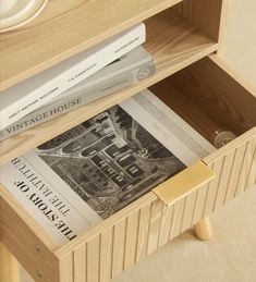 two books are sitting on top of a wooden shelf