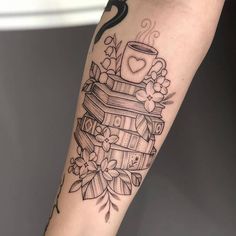 a tattoo on the arm of a woman with a cup of coffee and books