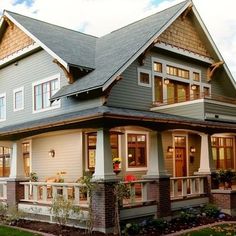 a large gray house with lots of windows on the front and side of it's roof