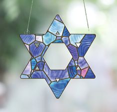 a stained glass star ornament hanging from a string