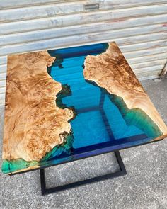 a table made out of wood with blue glass in the center and water running through it